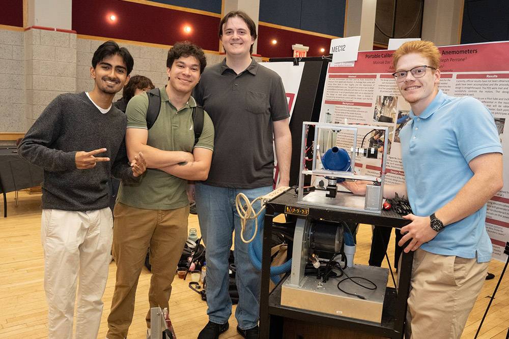 Group of four students surrounding wind machine project