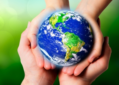 Two pairs of hands cradling a mini Earth model