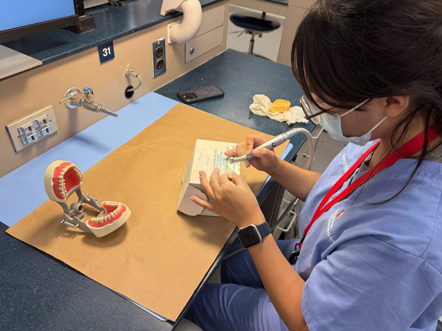 A dental participant practicing with tools