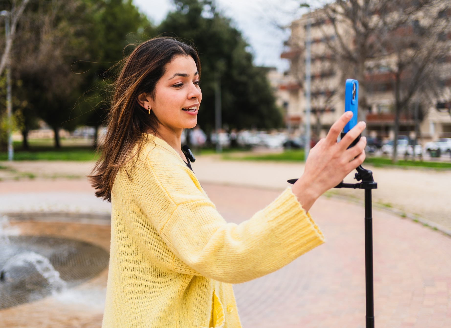A high schooler setting up her smartphone on a tripod to film a video